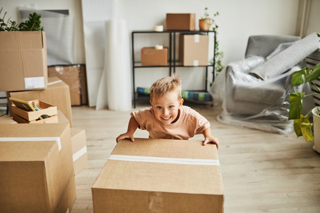 smiling boy moving boxes in new home 2022 01 18 23 51 13 utc