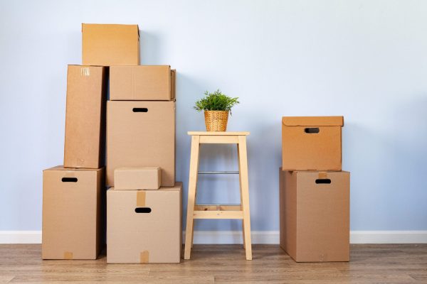 Moving boxes with packed stuff and chair for moving. Close up.